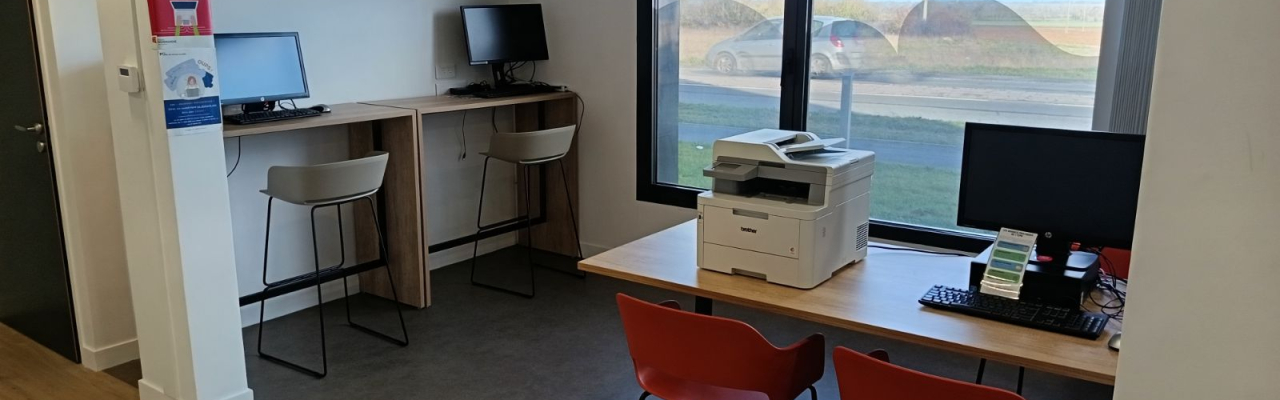 Open space équipé de trois ordinateurs fixes et d'une imprimante scanner.